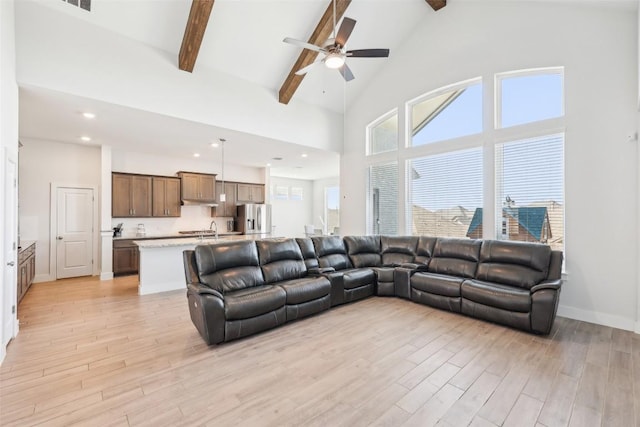 living area with light wood finished floors, baseboards, ceiling fan, beamed ceiling, and high vaulted ceiling