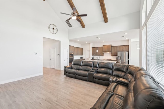 living room with baseboards, light wood-type flooring, beam ceiling, high vaulted ceiling, and a ceiling fan