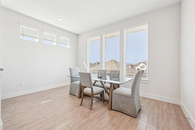 dining space with baseboards and light wood-style floors