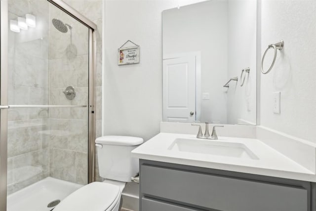 full bathroom with a shower stall, vanity, and toilet