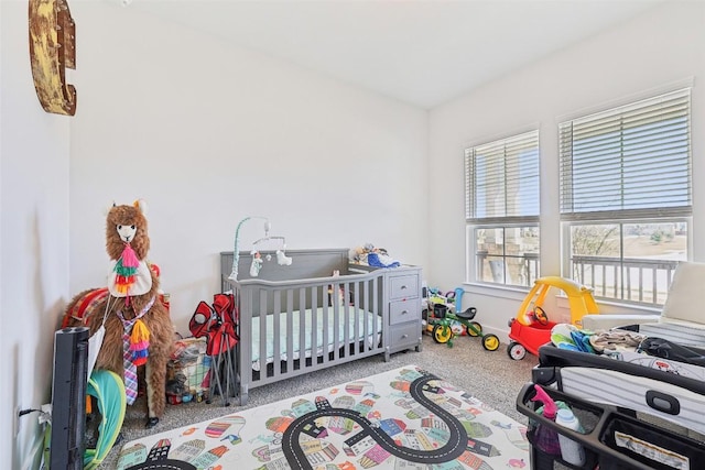 carpeted bedroom with a nursery area