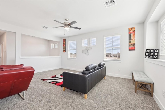 carpeted living area featuring visible vents, baseboards, and ceiling fan