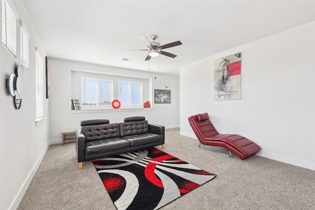 living area with baseboards, a ceiling fan, and carpet floors