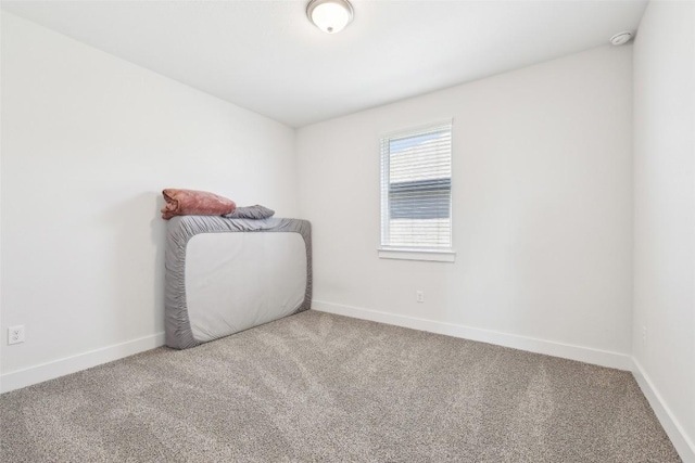 unfurnished room featuring carpet flooring and baseboards