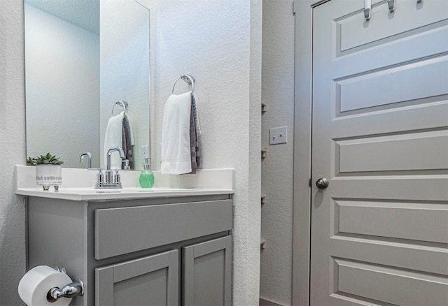 bathroom featuring vanity and a textured wall