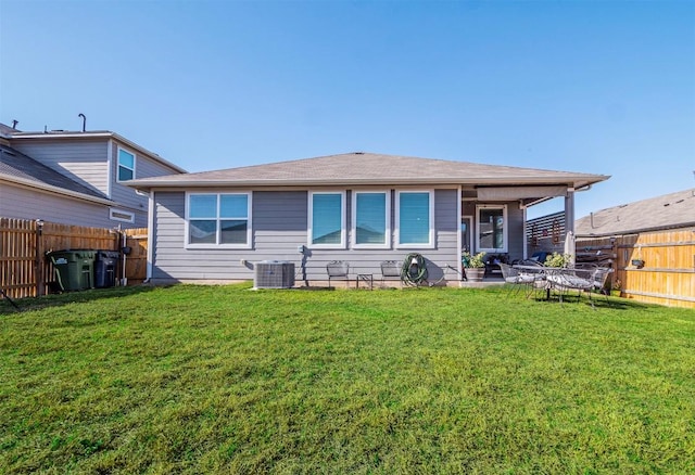 rear view of property with a fenced backyard, central air condition unit, a patio area, and a yard