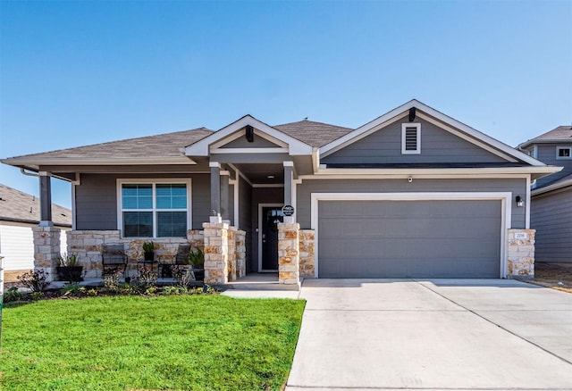 craftsman-style house with roof with shingles, an attached garage, concrete driveway, a front lawn, and stone siding