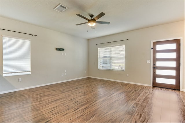 foyer featuring wood finished floors, ceiling fan, and baseboards