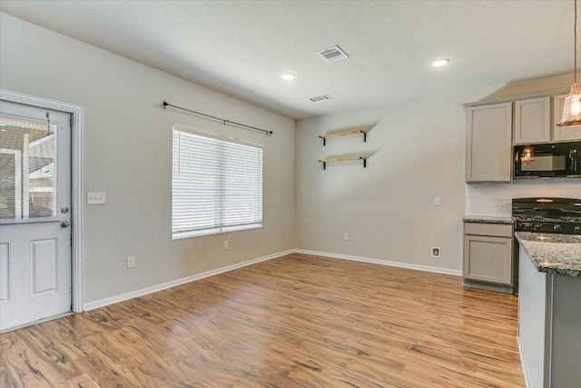 300 Eagle Lake Dr, Hutto, TX 78634 - kitchen featuring black microwave, stove, gray cabinetry, light wood-style floors, and recessed lighting