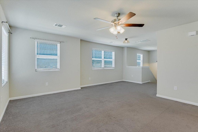 carpeted empty room with ceiling fan and baseboards