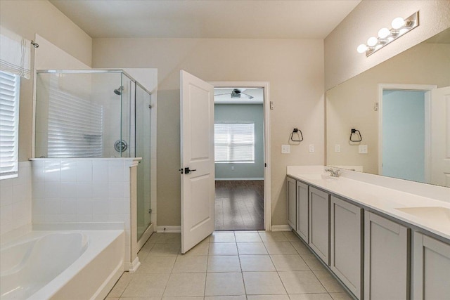 full bath featuring a shower stall, tile patterned flooring, a garden tub, and baseboards