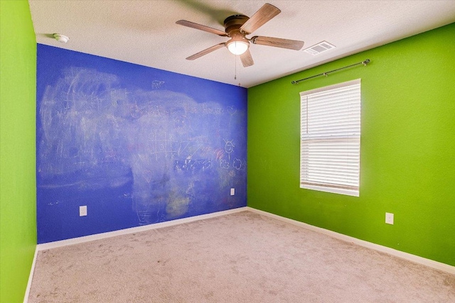 carpeted empty room featuring a ceiling fan, a smoke detector, and a textured ceiling