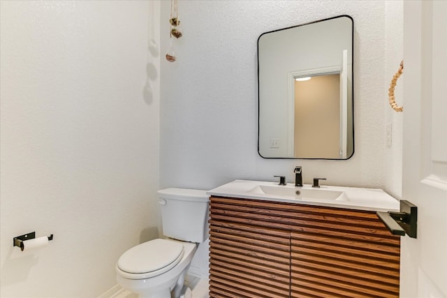 half bathroom featuring toilet and vanity