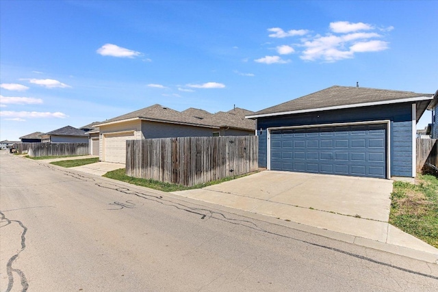 view of front of property with fence and a detached garage
