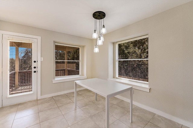 unfurnished dining area with light tile patterned flooring and baseboards