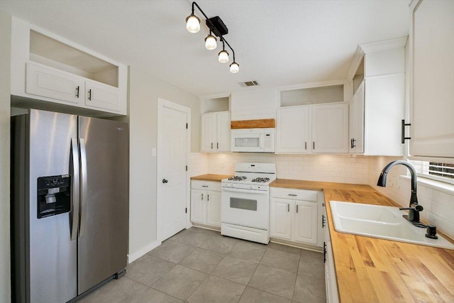 kitchen with a sink, white appliances, visible vents, and butcher block countertops