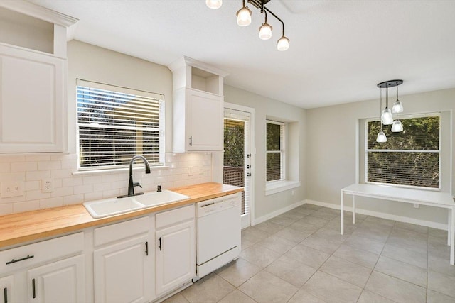 kitchen with white dishwasher, a sink, pendant lighting, wood counters, and tasteful backsplash