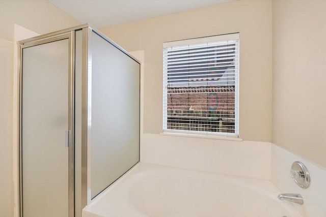 bathroom with a bath and a shower stall