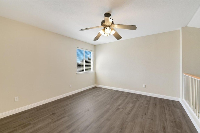 empty room with dark wood-type flooring, baseboards, and ceiling fan