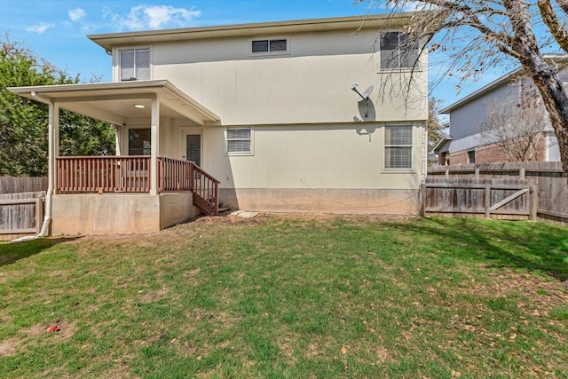 rear view of house with a yard and fence