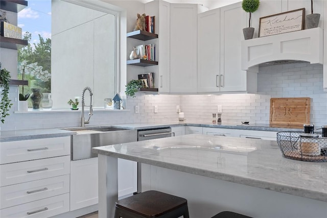 kitchen with tasteful backsplash, a kitchen bar, light stone counters, white cabinetry, and open shelves