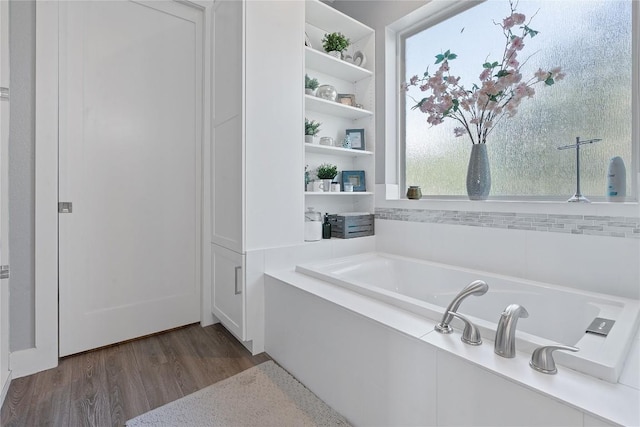 full bathroom featuring a garden tub and wood finished floors