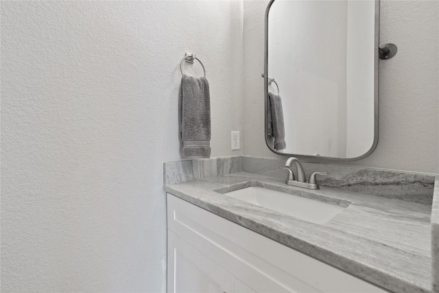 bathroom featuring vanity and a textured wall