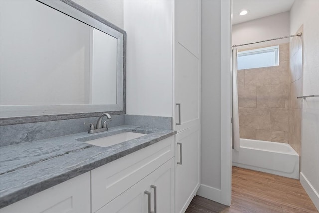 full bath featuring shower / bathtub combination with curtain, baseboards, wood finished floors, and vanity