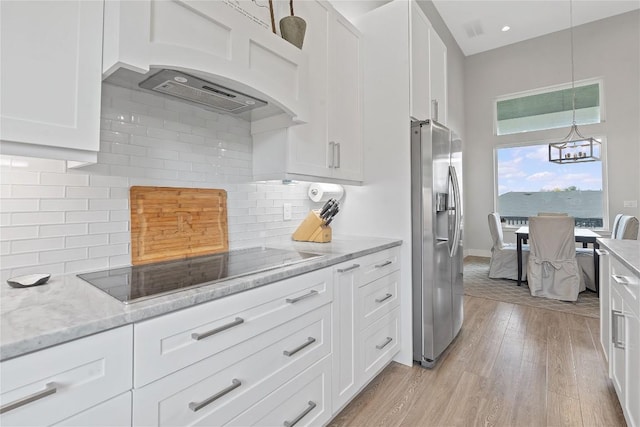 kitchen with light wood-type flooring, black electric cooktop, white cabinets, and stainless steel fridge with ice dispenser