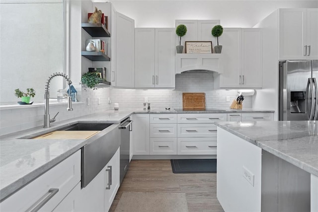 kitchen with tasteful backsplash, light stone counters, appliances with stainless steel finishes, white cabinets, and open shelves