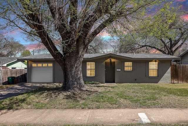 ranch-style home with a garage, brick siding, driveway, and fence