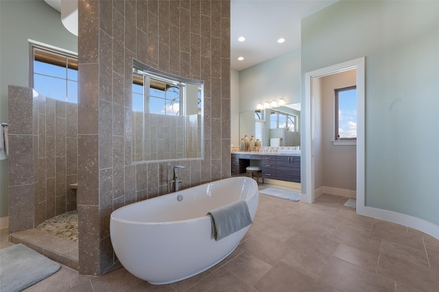 full bathroom with tile walls, a freestanding tub, a healthy amount of sunlight, and walk in shower