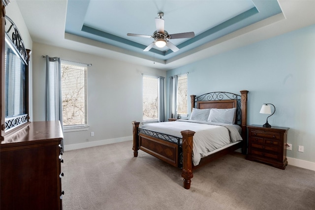 bedroom featuring baseboards, a raised ceiling, and carpet flooring