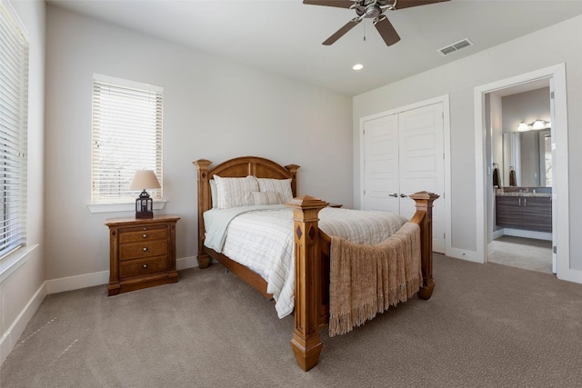 bedroom with visible vents, connected bathroom, baseboards, carpet flooring, and a closet