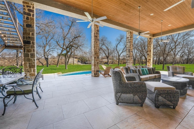 view of patio with outdoor dining space, an outdoor hangout area, stairs, and ceiling fan