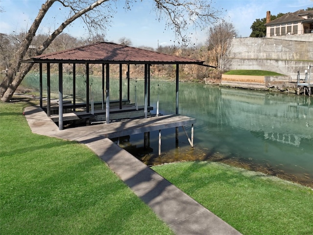 view of dock with a lawn and a water view