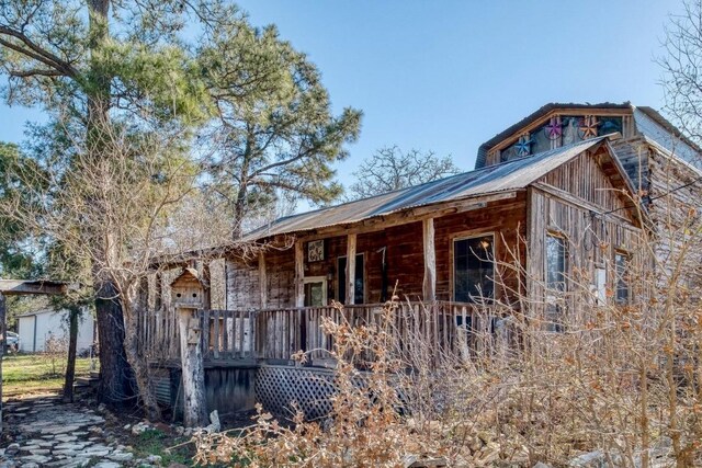view of side of property featuring an outbuilding and metal roof