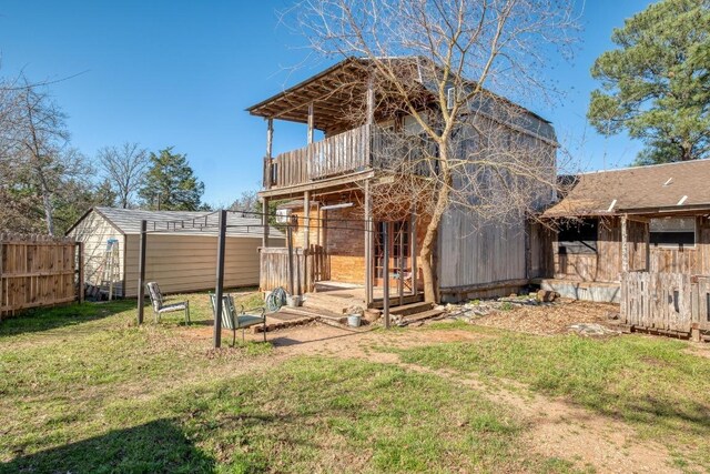 view of yard featuring an outbuilding, fence, and a shed