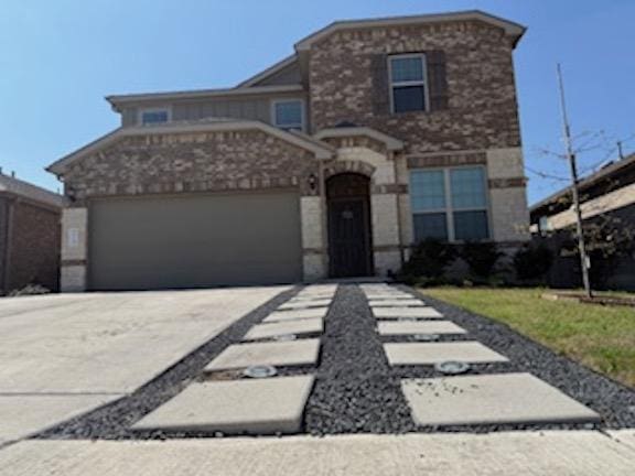 view of front of home featuring concrete driveway, a garage, and stone siding