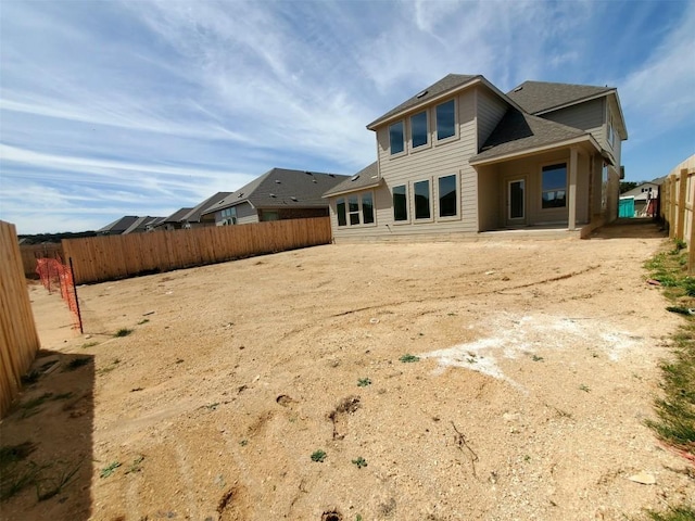 rear view of house featuring a fenced backyard