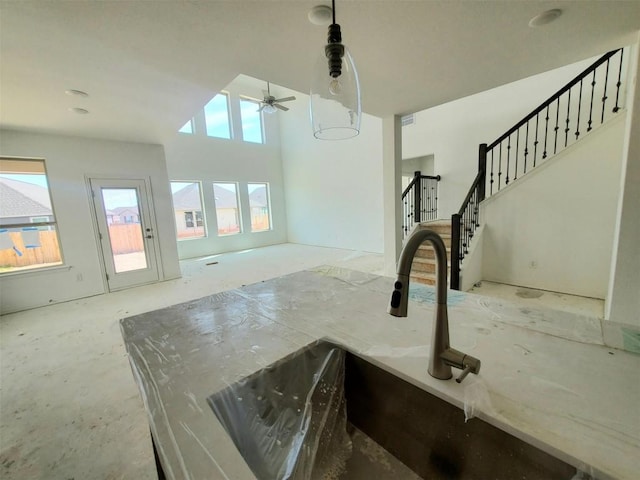 interior space with stairway, a ceiling fan, and a towering ceiling