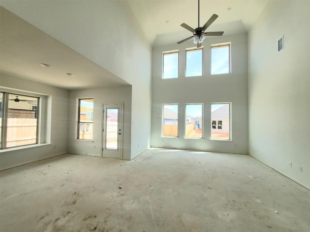 interior space featuring unfinished concrete flooring, visible vents, a high ceiling, and ceiling fan