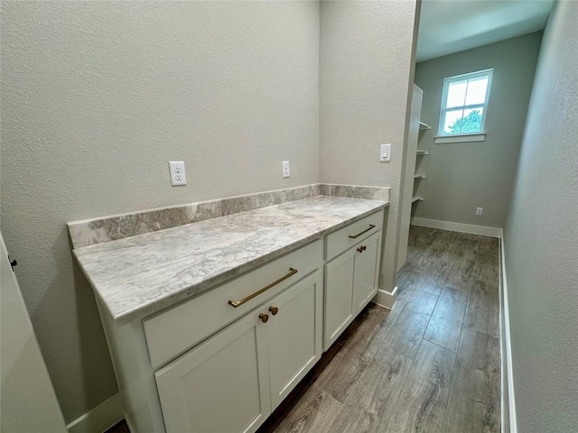 15 Persimmon Dr, Wimberley, TX 78676 - bathroom with wood finished floors, a textured wall, vanity, and baseboards