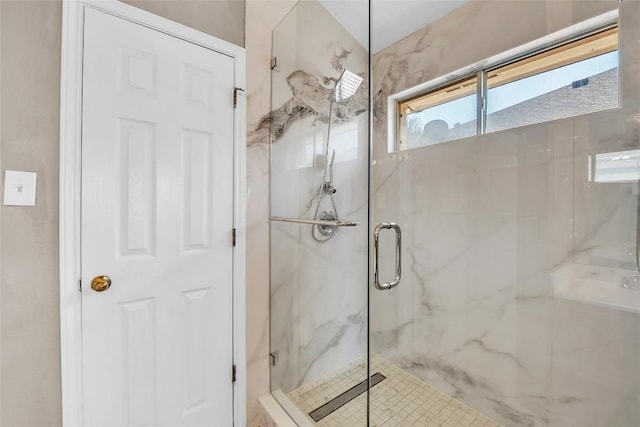 bathroom featuring a marble finish shower