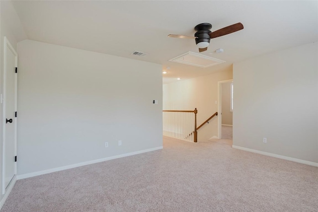 empty room with visible vents, light carpet, baseboards, and ceiling fan