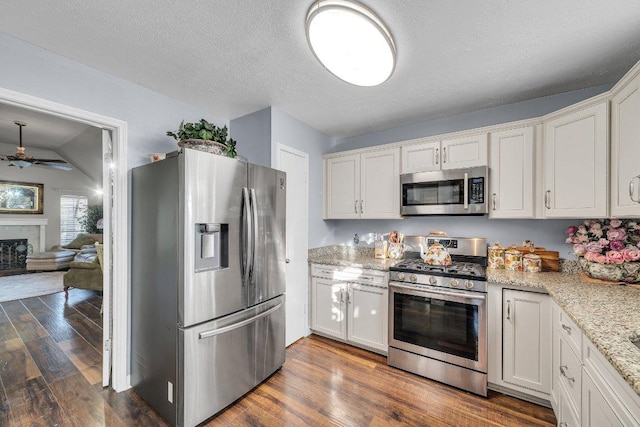 kitchen featuring dark wood-type flooring, white cabinetry, stainless steel appliances, and a ceiling fan