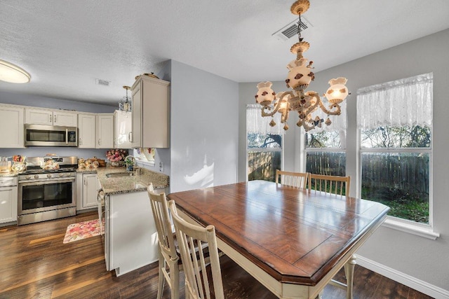 dining area featuring baseboards, visible vents, a chandelier, and dark wood finished floors
