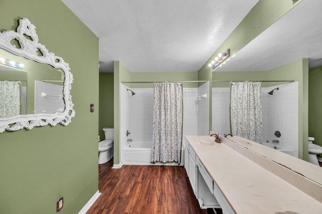 bathroom featuring toilet, vanity, a textured ceiling, and wood finished floors