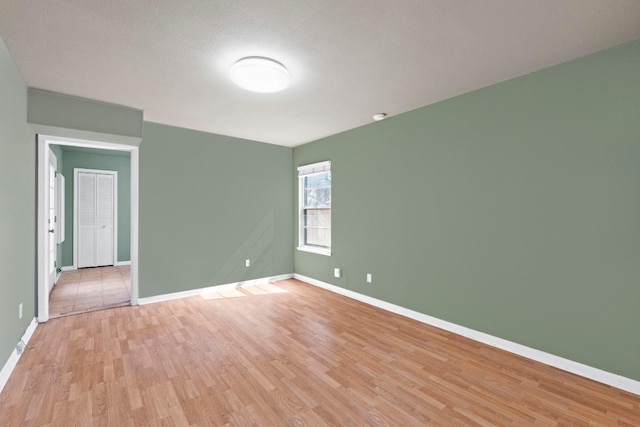 spare room with light wood finished floors and baseboards