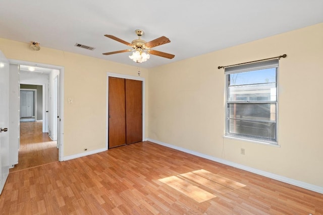 unfurnished bedroom with visible vents, light wood-style flooring, a closet, baseboards, and ceiling fan